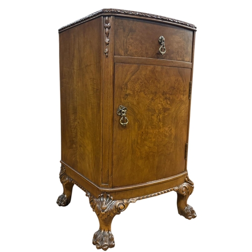 188 - A VINTAGE WALNUT PEDESTAL of demi lune outline the shaped top above a frieze drawer and cupboard on ... 