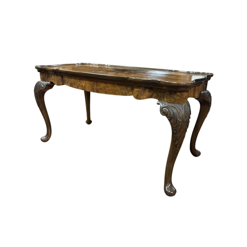 225 - A VINTAGE WALNUT AND MAHOGANY COFFEE TABLE of rectangular shaped outline the dish shaped top raised ... 