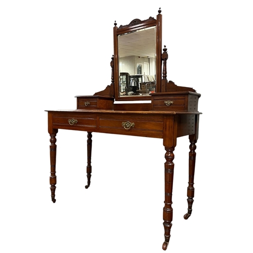 204 - AN EDWARDIAN MAHOGANY DRESSING TABLE the superstructure with bevelled glass swivel mirror raised on ... 