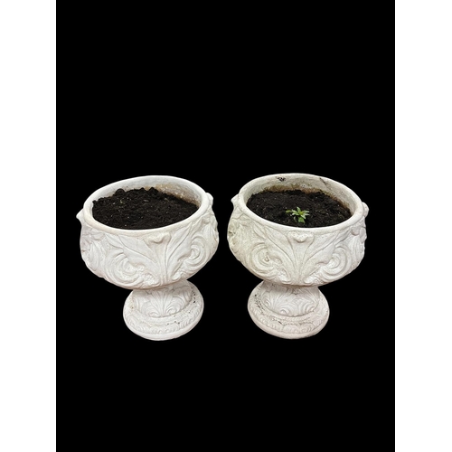 223 - A PAIR OF COMPOSITION STONE GARDEN URNS each of cylindrical form moulded in relief with stylised fol... 