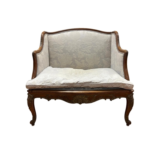 229 - A 19TH CENTURY CONTINENTAL CARVED WALNUT AND UPHOLSTERED SETTEE the serpentine top rail above an uph... 