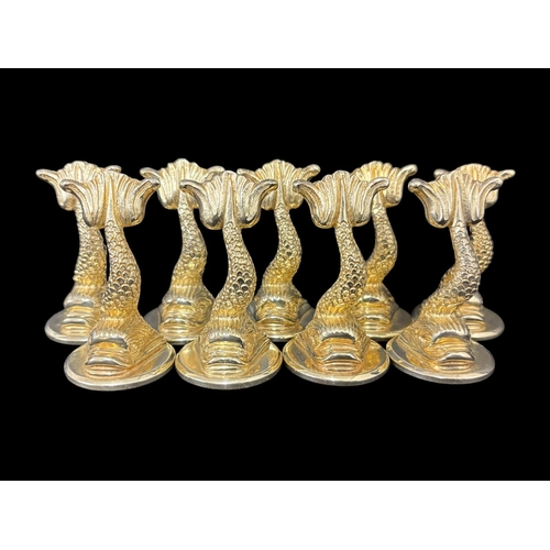 A SET OF NINE SILVER GILT MENU HOLDERS in the form of dolphins with tails aloft London 1983 Aspery 925g (29.7 troy oz)