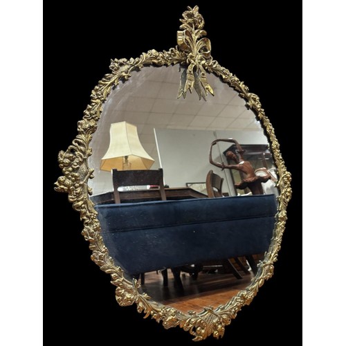 115 - A CONTINENTAL GILT FRAME MIRROR the rectangular bevelled glass plate with oval embossed  panel withi... 