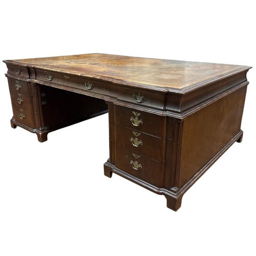 65 - A GEORGIAN STYLE MAHOGANY PARTNER'S DESK the shaped top with tooled leather inset above three frieze... 