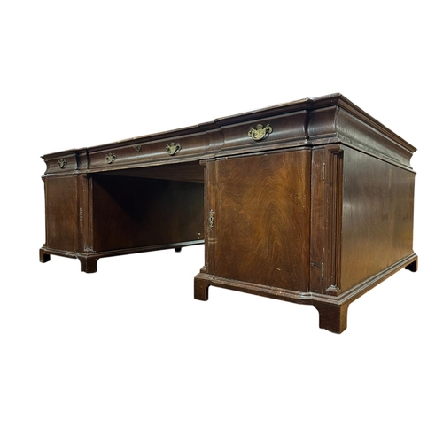 65 - A GEORGIAN STYLE MAHOGANY PARTNER'S DESK the shaped top with tooled leather inset above three frieze... 