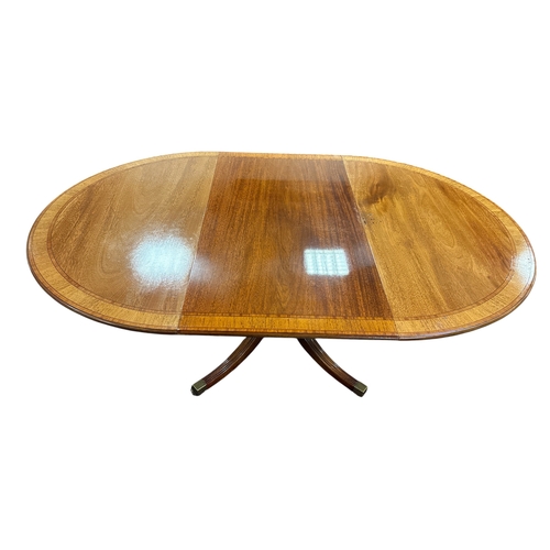 31 - A GEORGIAN STYLE MAHOGANY AND SATINWOOD INLAID DINING TABLE the oval top with one loose leaf raised ... 