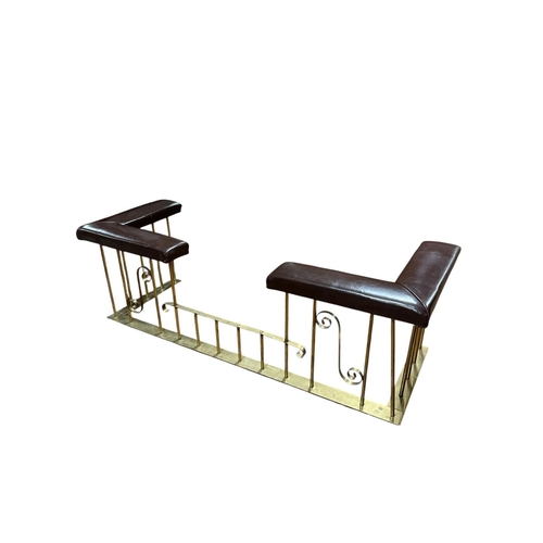 315 - A VINTAGE BRASS CLUB FENDER the L-shaped hide upholstered seats raised on cylindrical supports joine... 