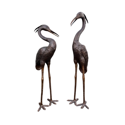 A FINE PAIR OF CAST BRONZE FIGURAL SCULPTURES depicting upright herons with details textured feathering 104cm (h)