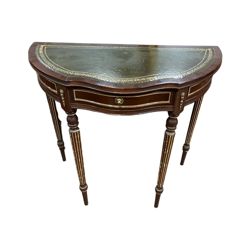 334 - A VINTAGE MAHOGANY SIDE TABLE of breakfront demi lune outline with tooled leather top over a conform... 