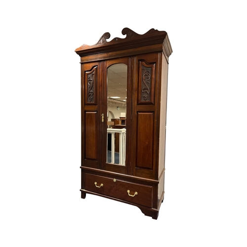 383 - AN EDWARDIAN MAHOGANY WARDROBE the carved swan neck pediment over a bevelled mirror panelled centre ... 