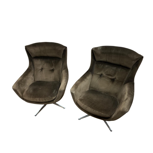 387 - A PAIR OF MIDCENTURY SWIVEL EGG CHAIRS the padded headrest over button back upholstery and formed ar... 