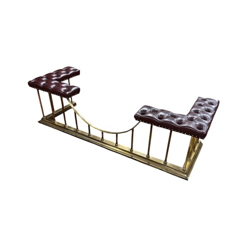A 19TH CENTURY STYLE BRASS AND LEATHER CLUB FENDER the button down oxblood upholstery over tubular supports on a moulded plinth base 49cm (h) x 183cm (w) x 62cm (d)