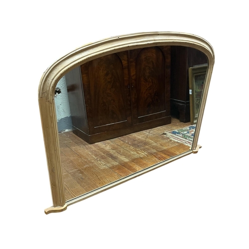 318 - A VINTAGE VERNACULAR PINE OVERMANTEL MIRROR the rectangular plate with domed top within a conformed ... 
