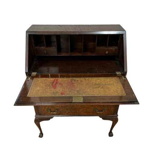 58 - A VINTAGE BURR WALNUT BUREAU the hinged writing slope containing pigeonholes and drawers with tooled... 