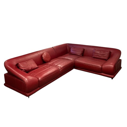AN ITALIAN DESIGN LEATHER CORNER SOFA with raked back and formed side over a stitched panel base on square cut timber feet 72cm (h) x 295cm (w) x 225cm (d)
