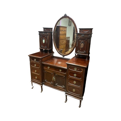 179 - AN EDWARDIAN MAHOGANY DRESSING TABLE the superstructure with oval bevelled glass mirror flanked on e... 