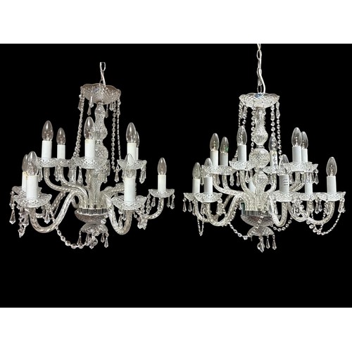 A FINE PAIR OF CONTINENTAL CUT GLASS TWELVE BRANCH CHANDELIERS in two registers hung with faceted chains and pendent drops 60cm drop x 60cm (w)