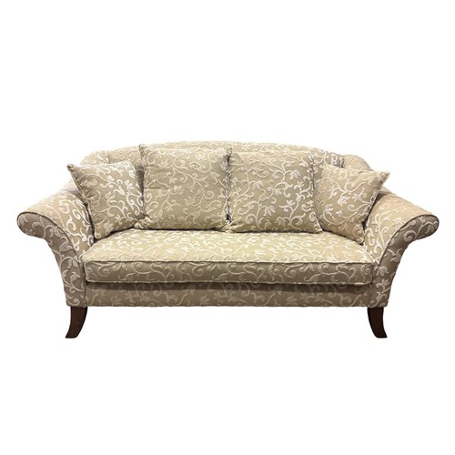 507 - A VINTAGE THREE SEATER SOFA upholstered in light olive green with off-white vinery the arched back a... 