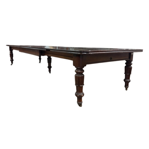A VERY FINE REGENCY MAHOGANY TELESCOPIC DINING TABLE with four loose leaves the rectangular top with rounded corners raised on leaf capped lobed legs with brass castors 76cm (h) x fully extended 483cm (l) x 137cm (w) Two leaves  80cm each (w), One leaf 77cm (w), One leaf 41cm (w)