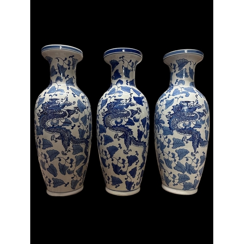 121 - A SET OF THREE CHINESE BLUE AND WHITE CERAMIC VASES with opposing dragon and phoenix decorations enc... 