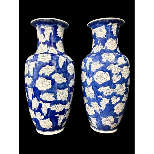432 - A PAIR OF VINTAGE CHINESE BLUE AND WHITE CERAMIC VASES with white lotus flower on a clouded blue und... 