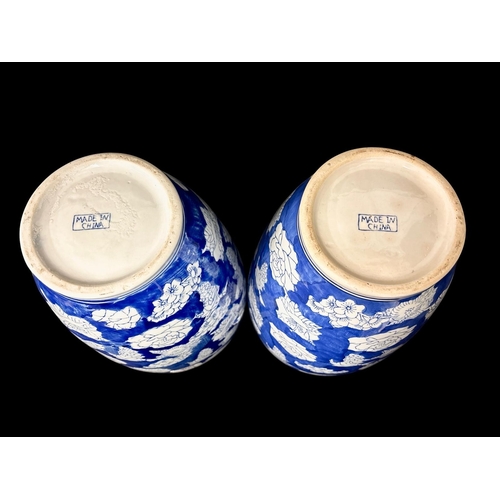 432 - A PAIR OF VINTAGE CHINESE BLUE AND WHITE CERAMIC VASES with white lotus flower on a clouded blue und... 