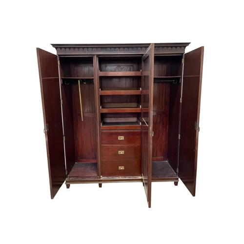 571 - AN EDWARDIAN FLAMED MAHOGANY ARMOIRE the central bevelled glass mirror plate opening onto sliding li... 