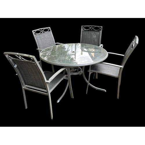 731 - A FIVE PIECE CONTEMPORARY PATIO SUITE comprising a table of circular outline with glass top and meta... 