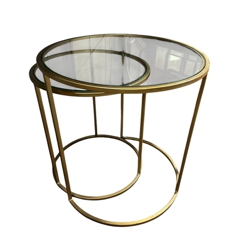 601 - A NEST OF TWO CONTINENTAL GILT METAL AND GLAZED TABLES each of circular form on tubular supports The... 