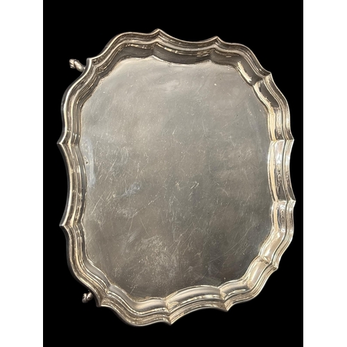 758 - A STERLING SILVER SALVER the shaped and moulded rim raised on four hooved feet Chester 1927 530g (17... 