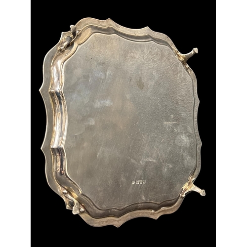 758 - A STERLING SILVER SALVER the shaped and moulded rim raised on four hooved feet Chester 1927 530g (17... 
