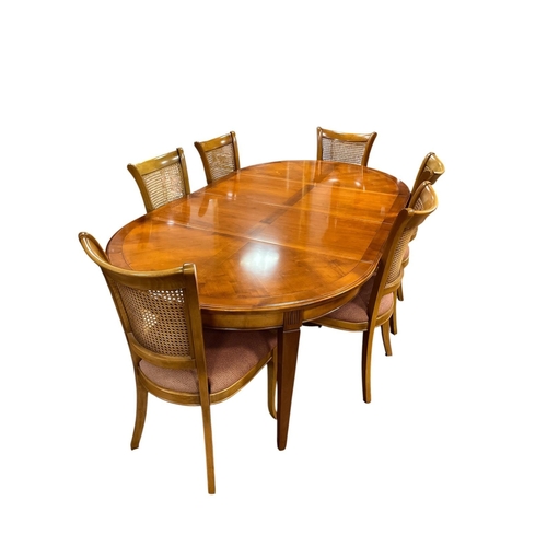65 - A CHERRYWOOD SEVEN PIECE DINING ROOM SUITE comprising a set of six chairs each with a curved top rai... 
