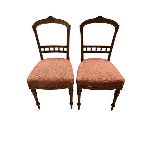 67 - A PAIR OF EDWARDIAN STAINED WOOD SIDE CHAIRS the arched top rail with spindle splats and upholstered... 