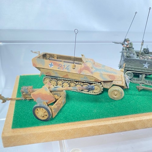 548 - Display case with two armoured vehicles, five field guns and figures, mainly Unimax - Good (1) 650g