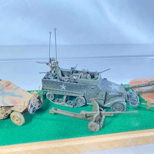 548 - Display case with two armoured vehicles, five field guns and figures, mainly Unimax - Good (1) 650g