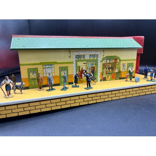 67 - Three Hornby O gauge tin plate trackside buildings and to include 13 O Gauge Dinky Figures shown in ... 