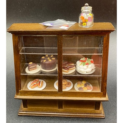 725 - Cake Shop. VG. 620g. (36)
Includes: Display Shelves, Side Board, Dining Table and 4 Chairs, 2 Charge... 