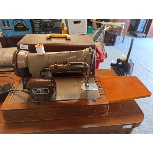 697 - A Singer Sewing Machine with side tray and leather case