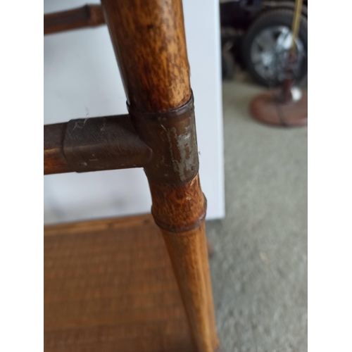 377 - A Vintage Bamboo and Rattan Table with lower shelf and metal banding