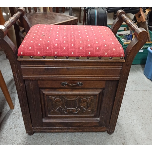 759 - An antique carved storage stool with lift up lid and magazine rack