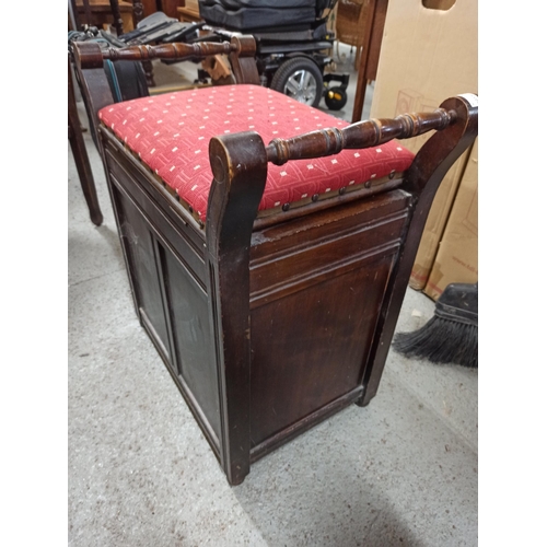 759 - An antique carved storage stool with lift up lid and magazine rack