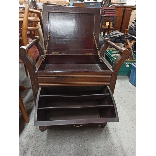 759 - An antique carved storage stool with lift up lid and magazine rack