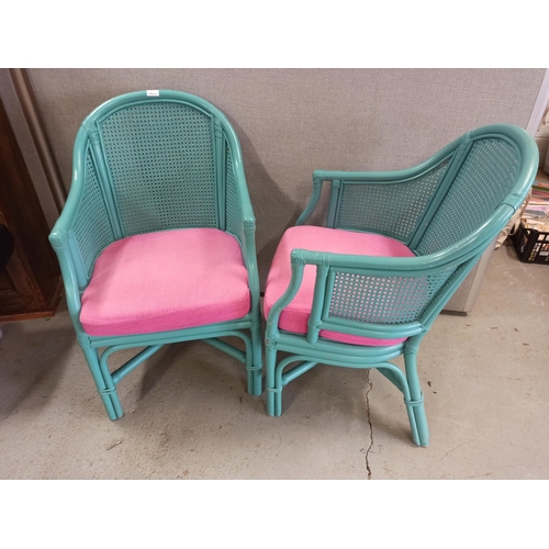 676 - 2 x Green Painted Rattan Armchairs with Pink Cushions