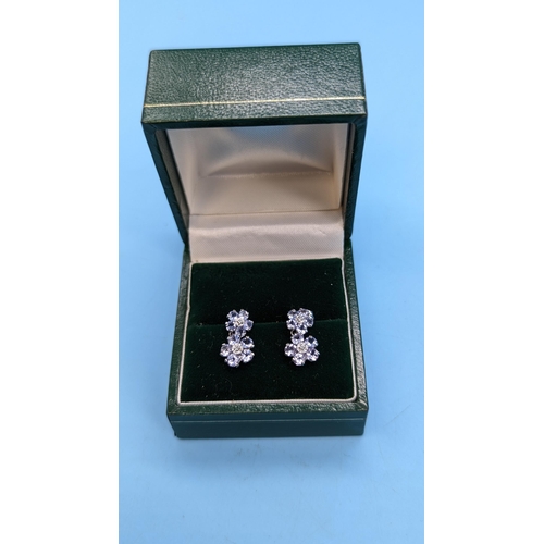 421 - A Pair of 10ct White Gold and Tanzanite Earrings 1.4 gms ( 1 butterfly clip missing)