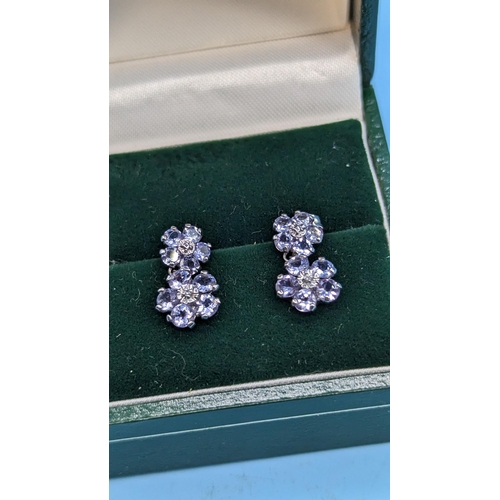 421 - A Pair of 10ct White Gold and Tanzanite Earrings 1.4 gms ( 1 butterfly clip missing)