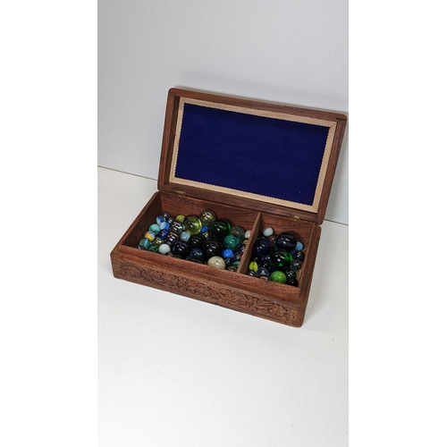 580 - A Carved Wooden Box Full Of Marbles.