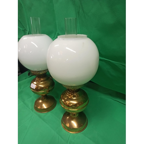 989 - A Pair of Brass Oil Lamps. Globe Glass Cracked On One Side As Pictured.