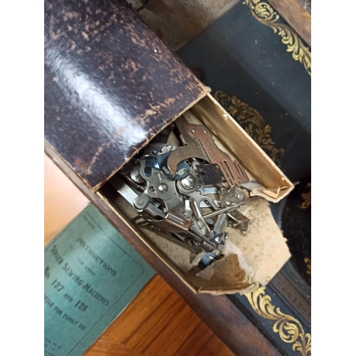 335 - A Singer Sewing Machine in a wooden Case With Instructions.