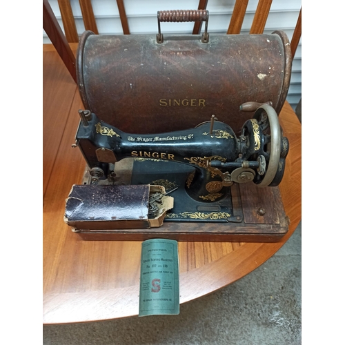 335 - A Singer Sewing Machine in a wooden Case With Instructions.