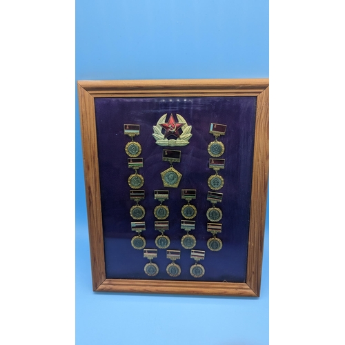 525 - A Framed Collection Of Russian Soviet Military Medals And Badges. C.C.C.P.